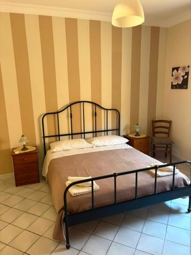 a bedroom with a bed and a striped wall at Brezza di mare in Zingarello