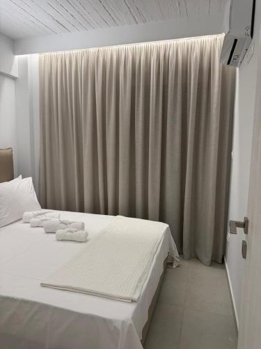 a bedroom with a white bed with towels on it at PJ Properties Sunset Residence Sounio in Sounio