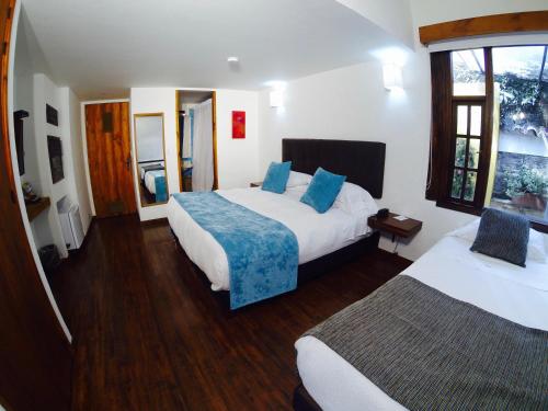 a hotel room with two beds and a window at Hotel Casona Usaquen in Bogotá