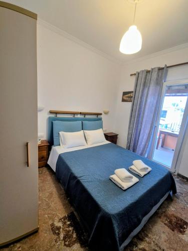 a bedroom with a blue bed with two towels on it at Anna Garden Sidari in Sidari
