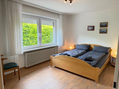 a bedroom with a bed and two windows at Steilsand 1 - 200 M Zum Strand in Cuxhaven