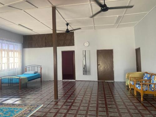 a room with two beds and a clock on the wall at Warisan Homestay A in Mersing