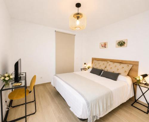 a bedroom with a white bed and a television at Arguineguin Sun Beach in Arguineguín