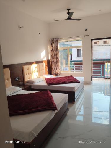 a bedroom with two beds and a window at Kunjapuri Homestay in Uttarkāshi