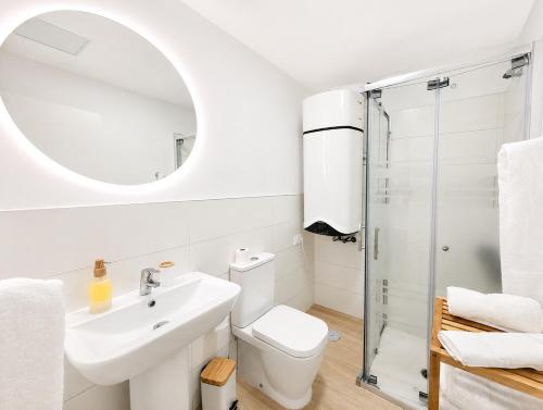a bathroom with a sink toilet and a mirror at Arguineguin Sun Beach in Arguineguín