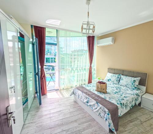 a bedroom with a bed and a balcony at Sunny Cozy Apartment Primorsko in Primorsko
