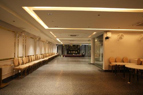 a long corridor with a row of chairs and tables at Hotel Madhuram Shivpuri MP in Shivpurī