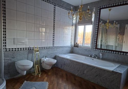 a bathroom with a tub and a toilet and a sink at Holiday Apartment Henry - Auszeit unter alten Balken in Arnstadt
