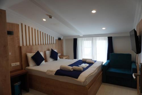 a bedroom with a large bed and a blue chair at Dünya Apart in Çaykara