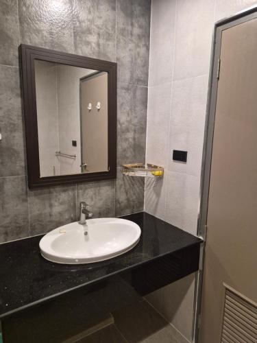 a bathroom with a sink and a mirror at New world condo1104 in Ban Chak Phai