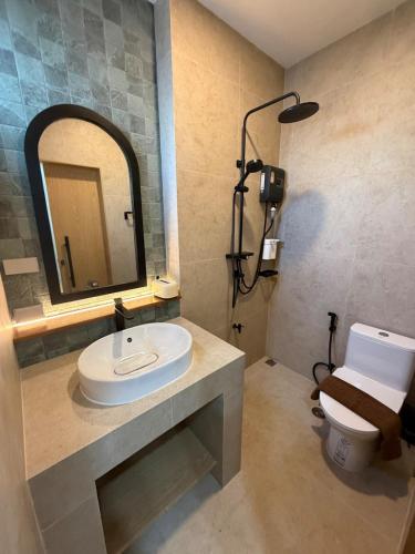 a bathroom with a sink and a mirror and a toilet at The Verona pool villa Hatyai in Ban Khlong Pleo