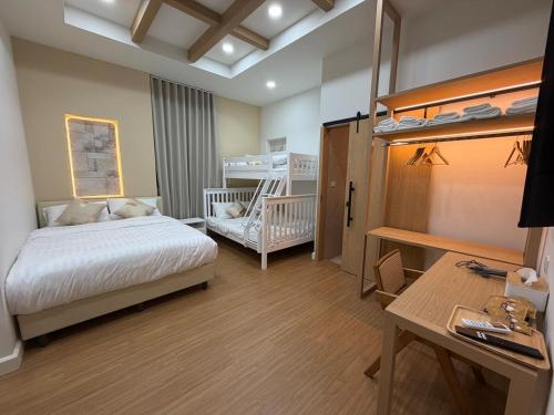 a bedroom with a bed and a desk and bunk beds at The Verona pool villa Hatyai in Ban Khlong Pleo