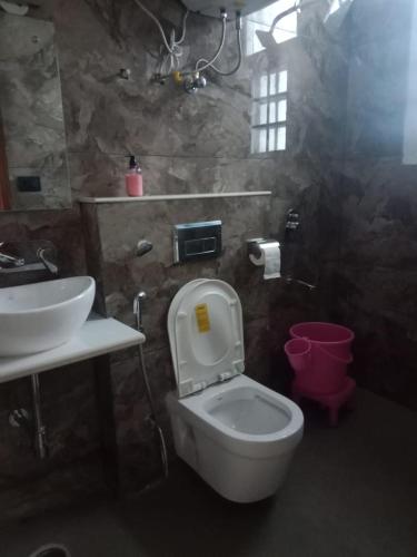 a bathroom with a white toilet and a sink at The Vista Retreat in Shimla