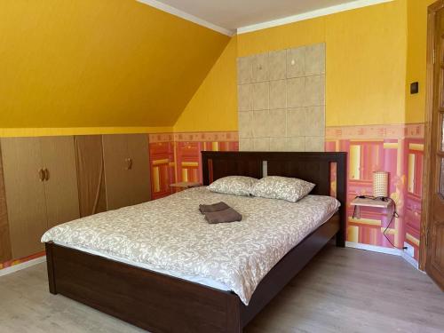 a bedroom with a bed in a room with yellow walls at Viesu nams Purenes in Vecmuiža