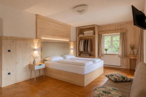 a bedroom with a large bed and a window at Naturhotel Wieserhof in Longostagno