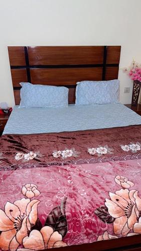 a bedroom with a bed with a red comforter at Prime Stay in Multan