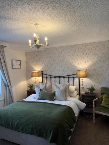 a bedroom with a large bed with green sheets and pillows at Bewerley Hall farm in Harrogate