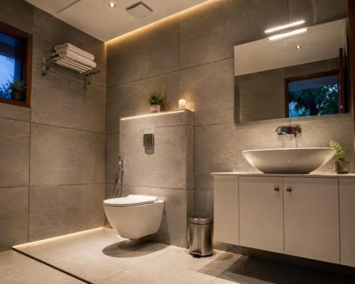 a bathroom with a white toilet and a sink at Athirapilly Fernvalley Resort in Athirappilly