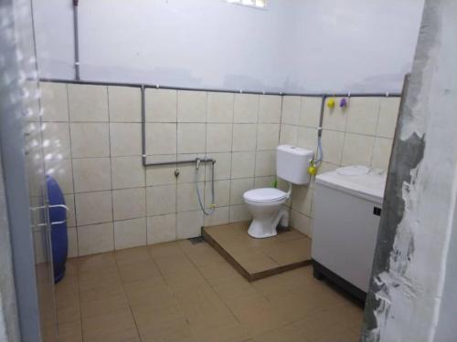 a bathroom with a toilet and a shower in it at Warisan Homestay B in Mersing