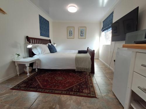 a bedroom with a large bed and a rug at Hope Street Studio in Kuilsrivier