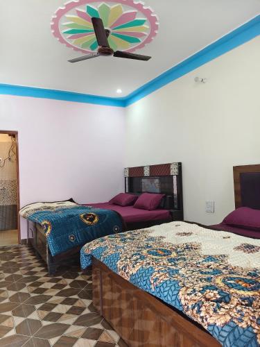 a room with two beds and a clock on the wall at Himalayan due homestay chopta in Sari