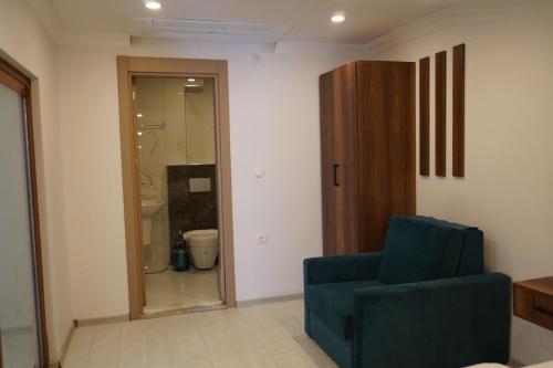a living room with a blue chair and a glass door at Dünya Apart in Çaykara