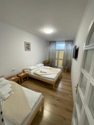 a hotel room with two beds and a window at Euro Apartman in Debrecen