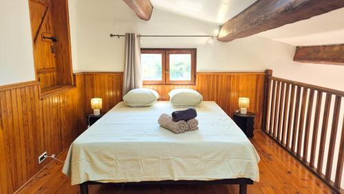 a bedroom with a bed with two pillows on it at Maison Aqua Bella - Terrasse - BBQ - 8pers in Contes