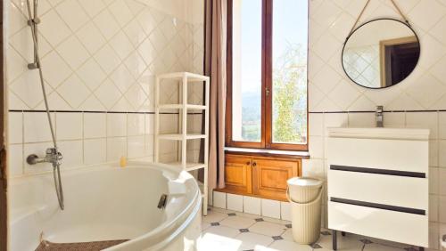a bathroom with a tub and a sink and a mirror at Maison Aqua Bella - Terrasse - BBQ - 8pers in Contes