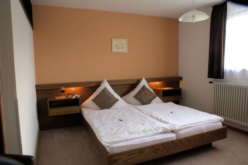 a bedroom with a bed with white sheets and pillows at Gasthaus Finken in Oppenau