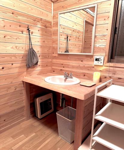 a bathroom with a sink and a microwave at Lodge Kurokawa 2 Forest in Minamioguni