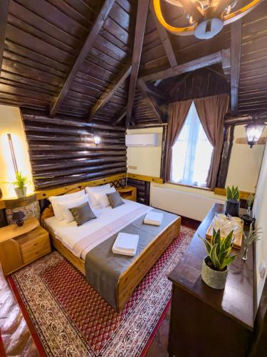 ein Schlafzimmer mit einem großen Bett und einer Holzdecke in der Unterkunft Etno Sobe in Smederevo