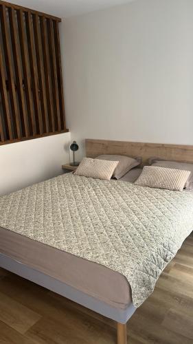 a bed in a bedroom with a wooden headboard at Charmant studio au coeur du centre ville historique - Les tailleurs in Sélestat