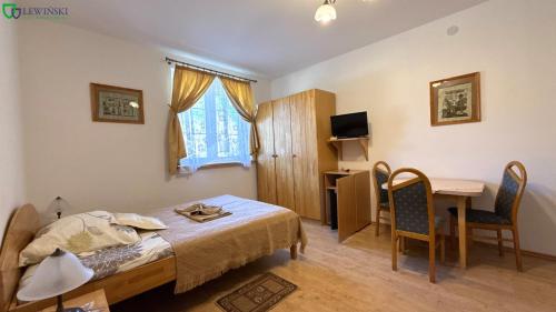 a bedroom with a bed and a table and a desk at Dworek Słoneczko in Smołdzino
