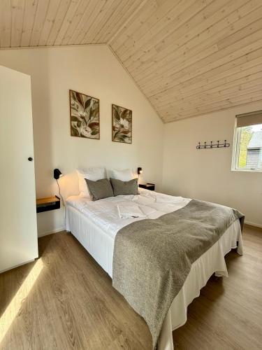a large bed in a room with a wooden ceiling at Feriebyens Spahuse in Rødvig