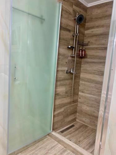 a shower with a glass door in a bathroom at Cherry Blossom Apartment in Xanthi