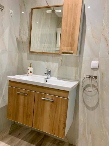 a bathroom with a sink and a mirror at Cherry Blossom Apartment in Xanthi