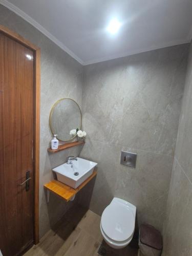 a bathroom with a sink and a toilet and a mirror at Anna Garden Sidari in Sidari