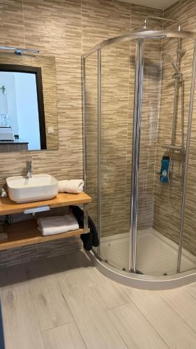 a bathroom with a glass shower and a sink at Canelas 22 in Sanxenxo