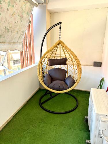 a room with a hanging chair on a balcony at Gemareia Lodge in Lefkada