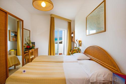 a bedroom with two beds and a window at Ecoresort Le Sirene - Caroli Hotels in Gallipoli