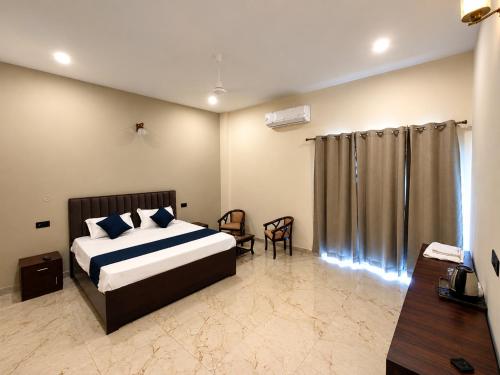 a bedroom with a bed and a chair in it at Glotus Hotel in Herbertpur