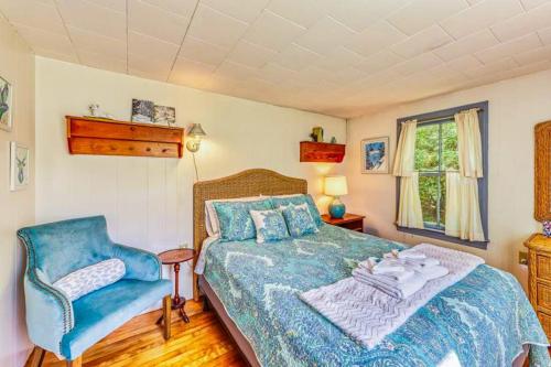 a bedroom with a bed and a blue chair at Gingerbread Cottage in Sugar Hill