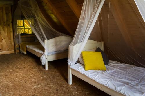 a bedroom with two beds in a tent at Sauna house with minilake in Voki