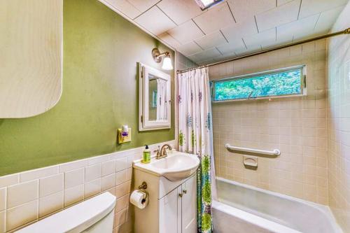 a bathroom with a sink and a toilet and a tub at Gingerbread Cottage in Sugar Hill