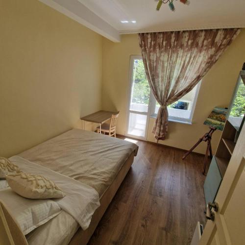 a bedroom with a bed and a window at Blue Dreams - City Center Burgas in Burgas