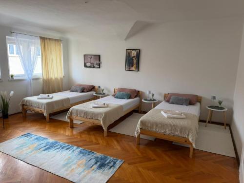 a living room with two beds and a rug at Rooms delux muro in Split