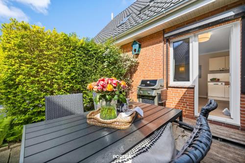 a wooden table with a vase of flowers on it at Ferienwohnung Windjammer 5 St Peter-Ording in Sankt Peter-Ording