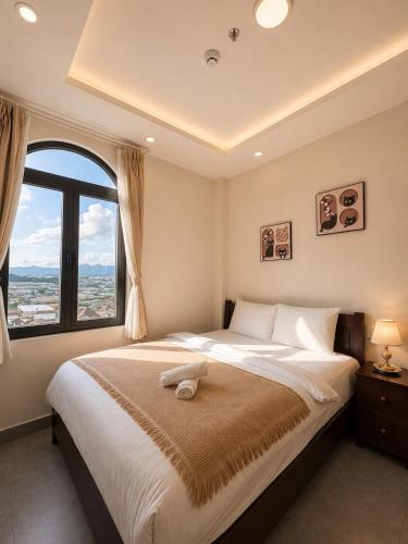 a bedroom with a large bed with a large window at Amelia House - Boutique Hotel in Khu Chi Lăng