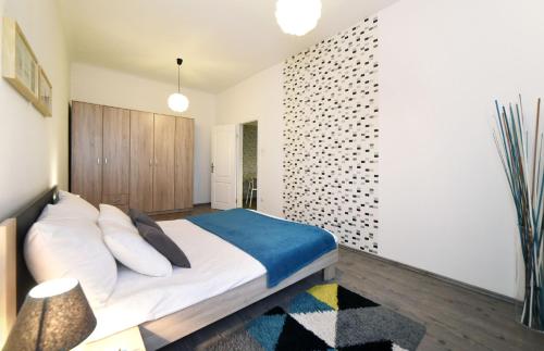 um quarto com uma cama com lençóis brancos e almofadas em Block Apartment em Zagreb